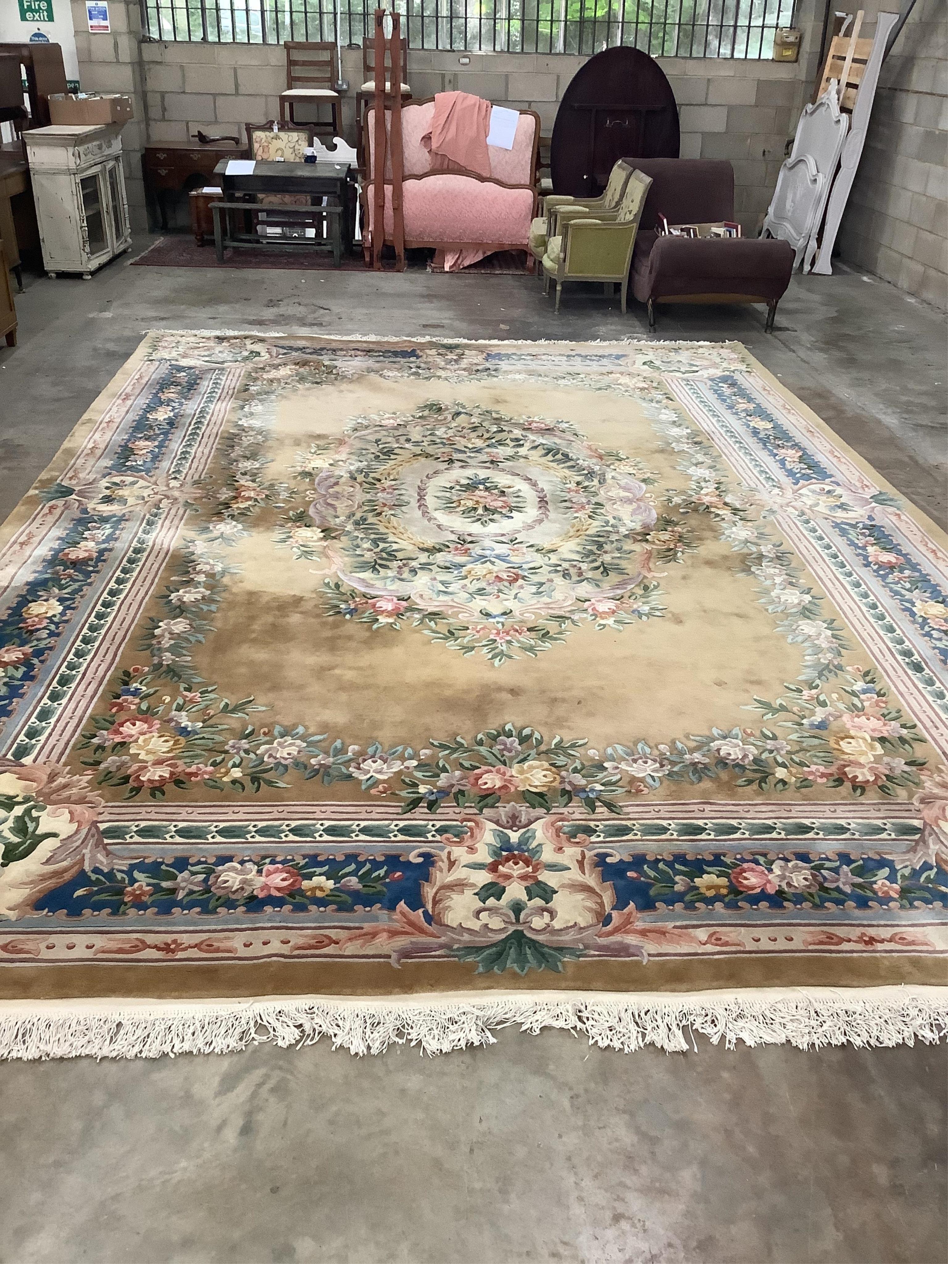 A large Chinese washed woollen gold ground floral embossed carpet, 560cm x 370cm. Condition - good